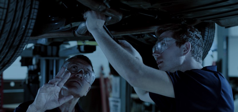Auto Technicians Examining Undercarriage of Vehicle