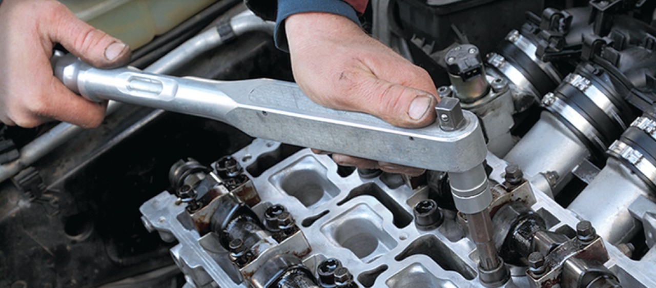 Auto technician working on engine.